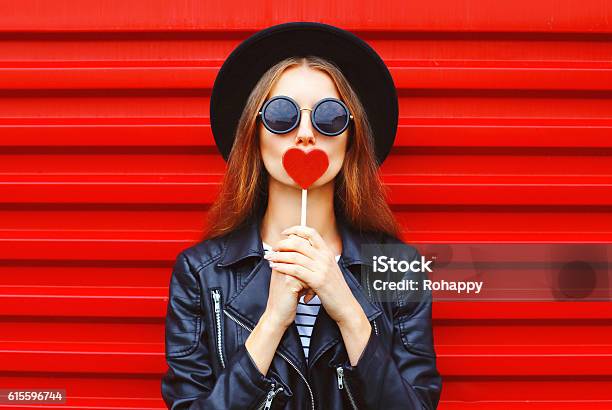 Fashion Pretty Young Woman With Red Lollipop Heart Wearing Black Stock Photo - Download Image Now