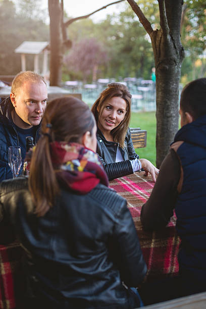 istock Four friends celebrating outdoors, talking and smiling 615596934