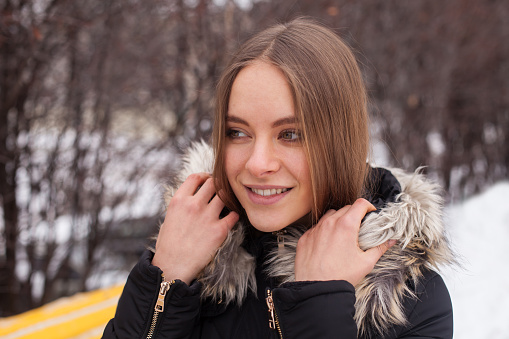 Portrait of young cute woman in winter standing outdoor
