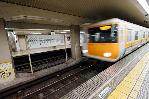 Osaka, Japan - November 30, 2015: Osaka subway station and motion blurred train.  In 2010 the greater Osaka region had 13 million rail passengers daily  of which the Osaka subway accounts for 2.29 million.