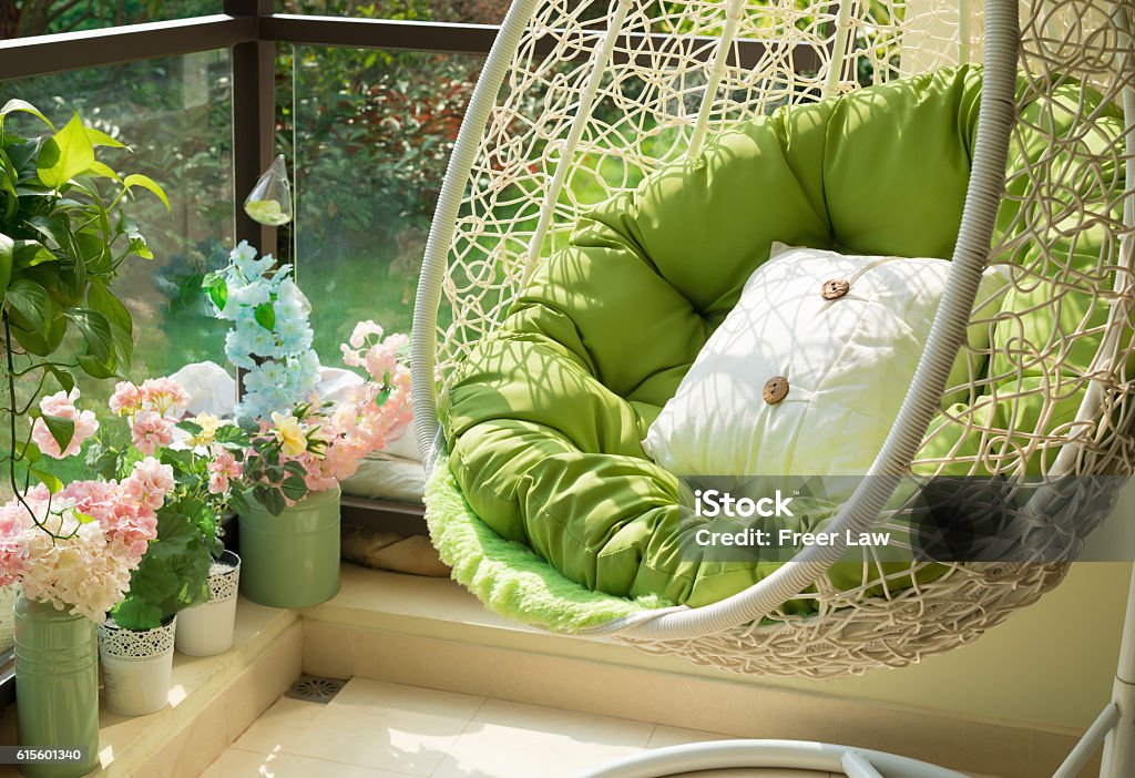 garden swing with mattress and cushion in a balcony garden swing with mattress and cushion in a balcony in the morning Balcony Stock Photo