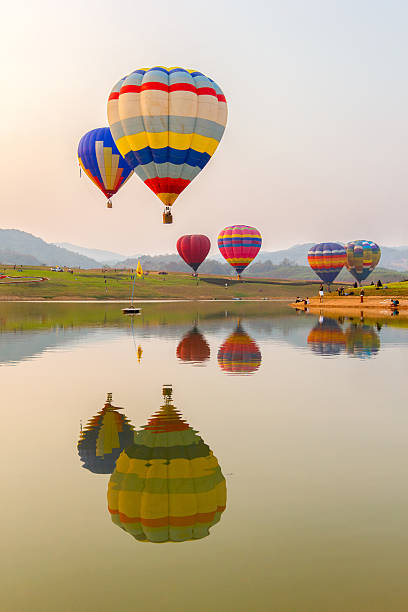 gorący balon na gorące powietrze nad jeziorem z zachodem słońca - spy balloon zdjęcia i obrazy z banku zdjęć