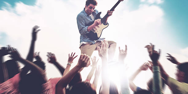 istock Young Man Guitar Performing Concert Ecstatic Crowds Concept 615602070