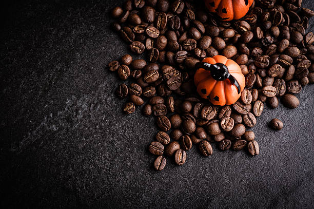 istock Halloween pumpkin decoration with coffee beans on dark background 615603468