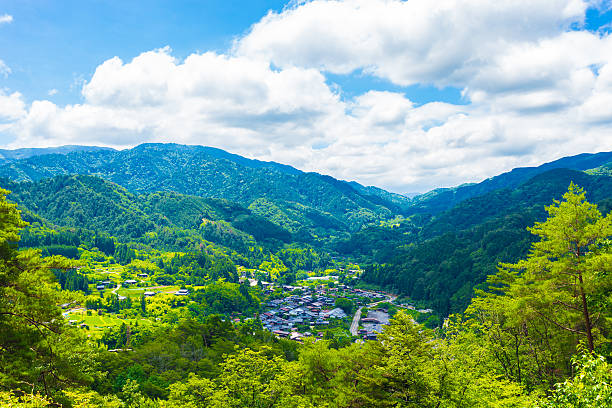 Tsumago Viewpoint Landscape H A view overlooking Tsumago village above the Magome-Tsumago portion of ancient Nakasendo Route from high angle viewpoint and former grounds of Tsumago castle in Japan on a blue sky day. Horizontal gifu prefecture stock pictures, royalty-free photos & images