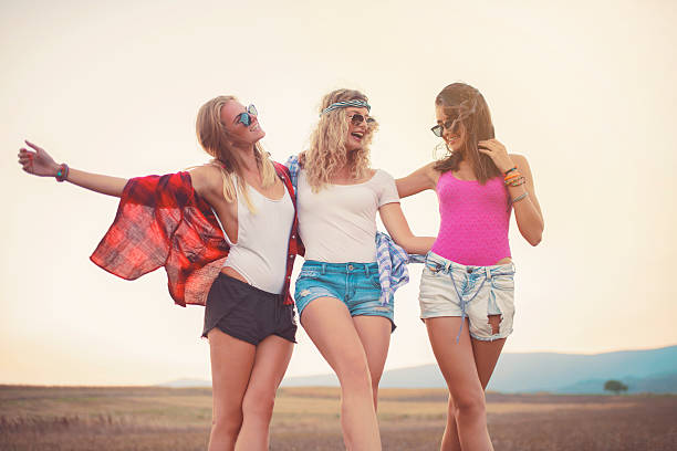 Three beautiful girls holding together, enjoying a carefree summer day outdoors.
