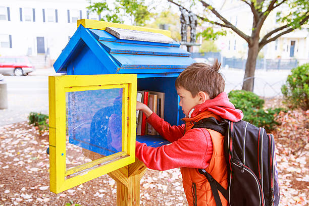 мальчик берет бесплатные книги на улице - free entrance стоковые фото и изображения