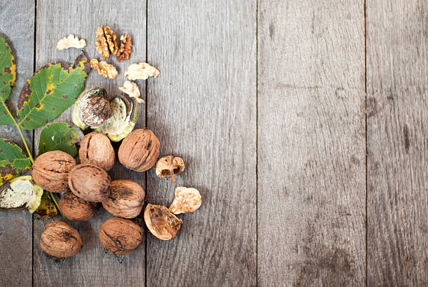 istock walnut on wooden background with leaves 615604774