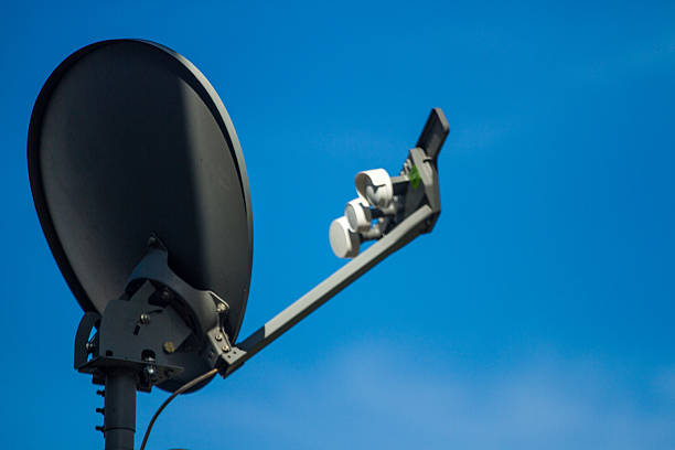 Satellite dish antenna on top of the building in urban area at night.