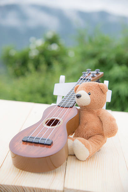 istock Teddy bears sitting on a chair with a ukulele blurred 615607950