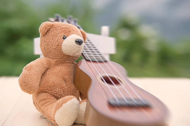 istock Teddy bears sitting on a chair with a ukulele blurred 615608050