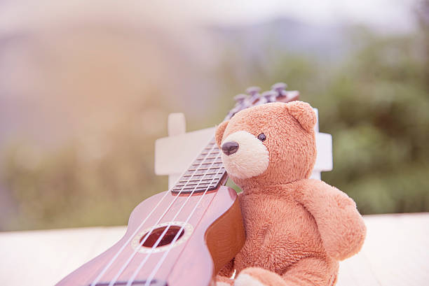 istock Teddy bears sitting on a chair with a ukulele blurred 615608128