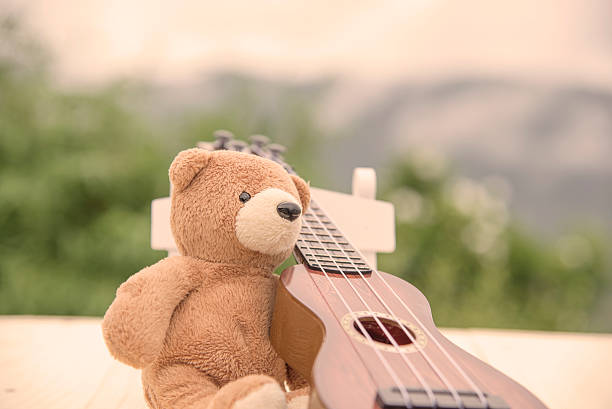istock Teddy bears sitting on a chair with a ukulele blurred 615608230