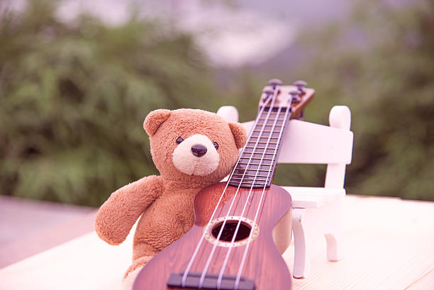 istock Teddy bears sitting on a chair with a ukulele blurred 615608316