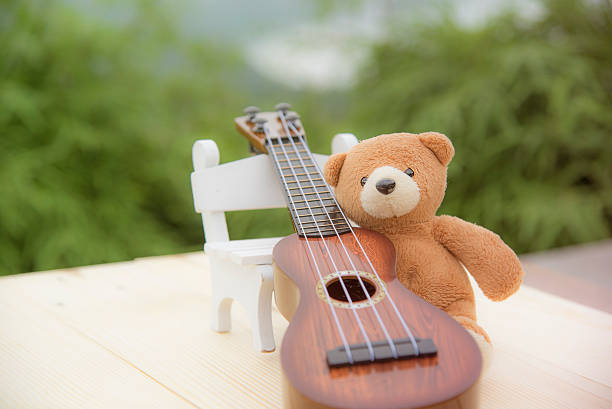 istock Teddy bears sitting on a chair with a ukulele blurred 615608702