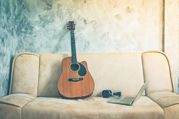 istock Guitar with laptop and headphone on a sofa. Vintage tone. 615608912