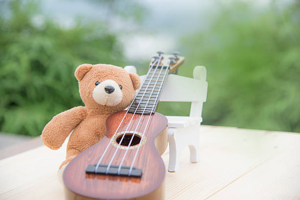 istock Teddy bears sitting on a chair with a ukulele blurred 615608960