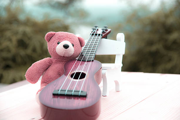 istock Teddy bears sitting on a chair with a ukulele blurred 615609116