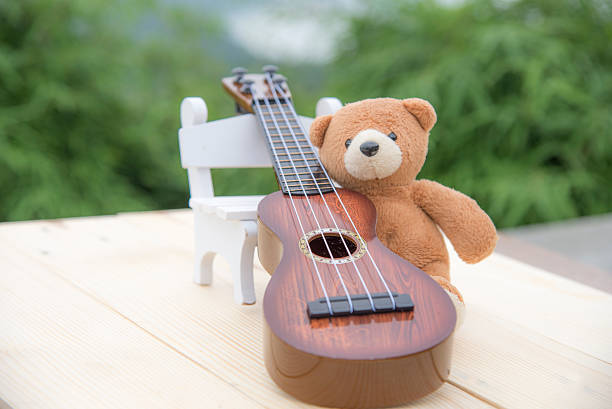 istock Teddy bears sitting on a chair with a ukulele blurred 615609356