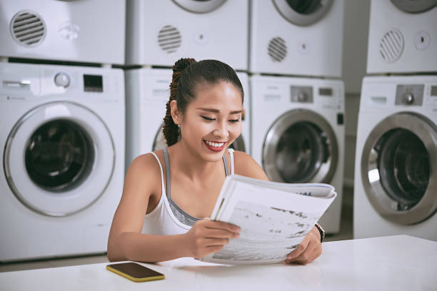 istock Woman in laundromat 615610438