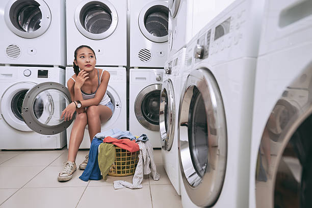 istock Pensive girl in laundromat 615610442