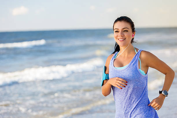 istock Confident woman jogs on the beach 615610638