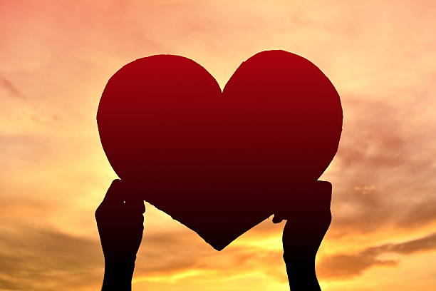 istock Silhouette girl hand holding heart shape 615612050