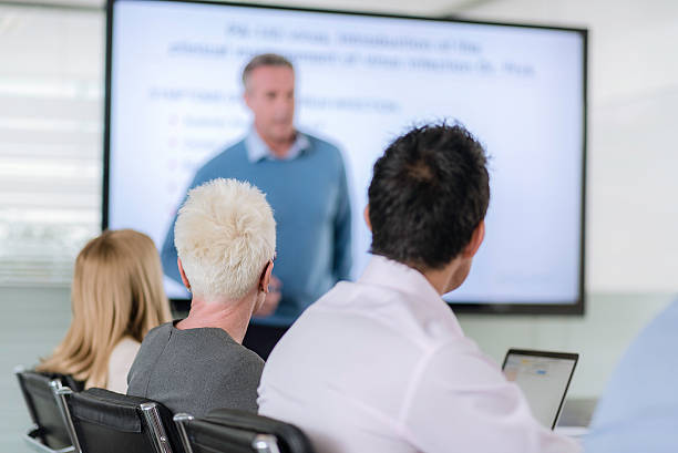 istock Man speaking in front of a screen 615616848