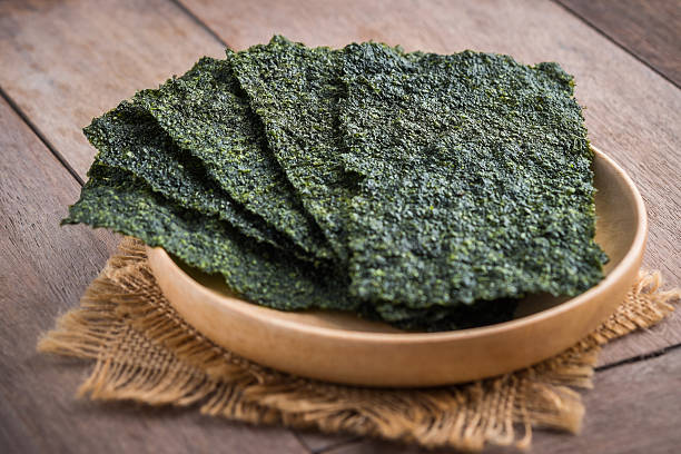 Crispy dried seaweed on wooden plate Crispy dried seaweed on wooden plate nori stock pictures, royalty-free photos & images