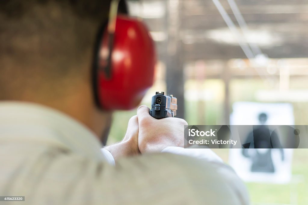 Shooting with Gun at Target in Shooting Range Shooting with Gun at Target in Shooting Range. Man Practicing Fire Pistol Shooting.Shooting with Gun at Target in Shooting Range. Man Practicing Fire Pistol Shooting. Target Shooting Stock Photo