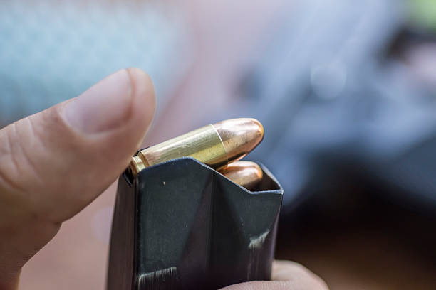 istock Loading Handgun Magazine. Bullets and Pistol Background. 615623850