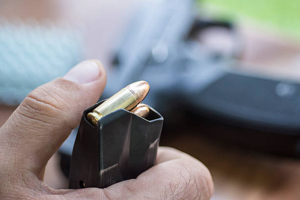 Load Ammo in the Pistol Clip. Hands, Bullets, and Handgun. Load 9mm Ammo in the Pistol Clip Close Up. Hands, Bullets, Magazine and Handgun. shooting guard stock pictures, royalty-free photos & images