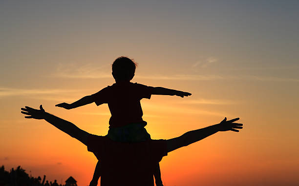 istock father and son having fun on sunset sky 615625956