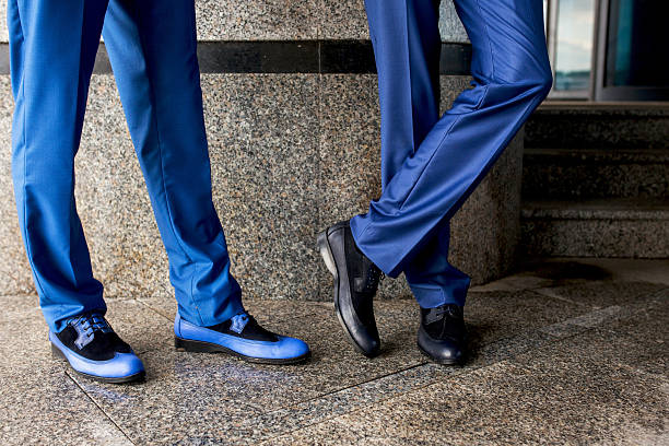 istock Legs of unrecognizable businessmen on a sidewalk. 615627474