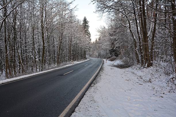 istock snowy road in the forest in winter 615629266