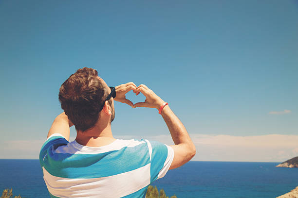 istock Man holding hands in heart-shape outdoors. 615630340