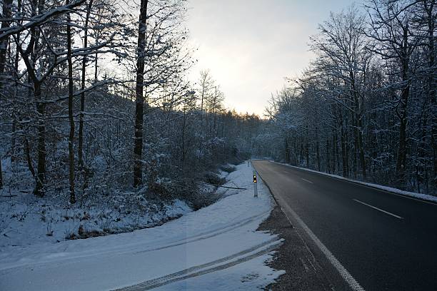 istock snowy road in the forest in winter 615630348