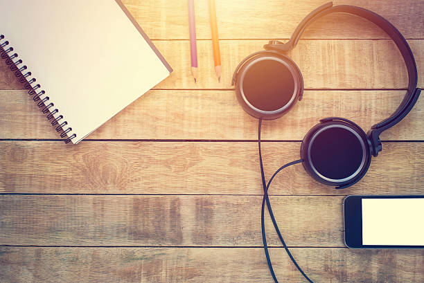 istock Blank notebook with pencil and earphone on wooden table 615631888