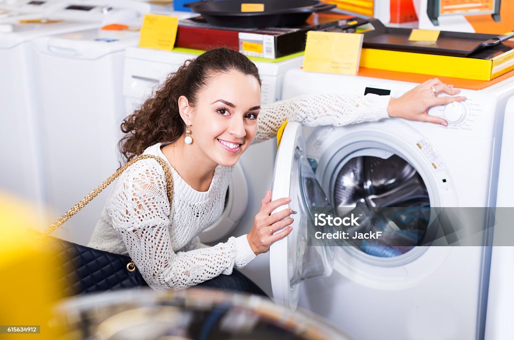 Customer looking at washers Female customer looking at washers and dryers in store Shopping Stock Photo
