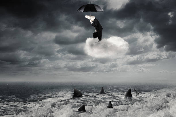 istock Man standing on the cloud above sharks 615635350