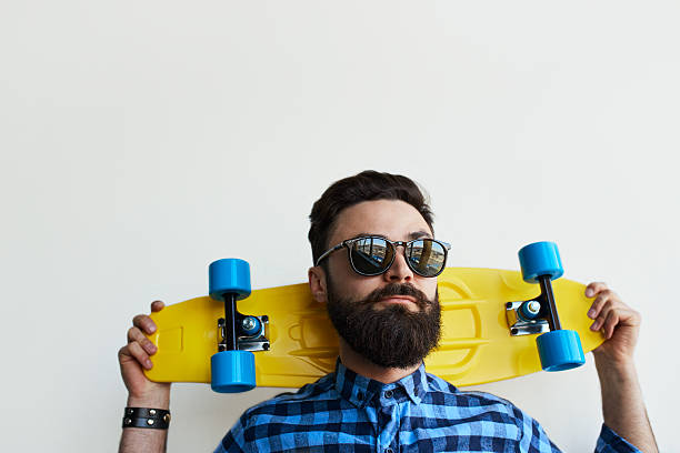 istock Handsome skateboarder, holding a skateboard behind his head. 615636564