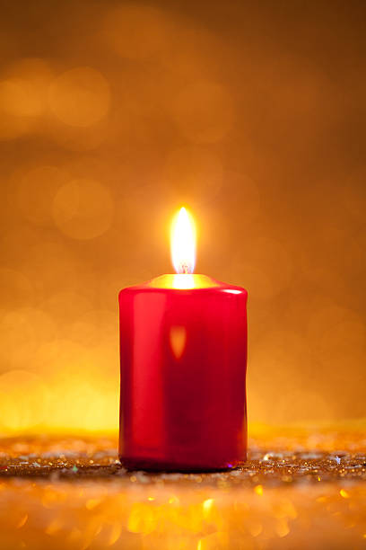 istock Red candle on gold glitter with yellow background 615637278