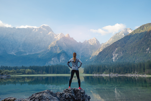 Woman standing on the rock. Success concept.