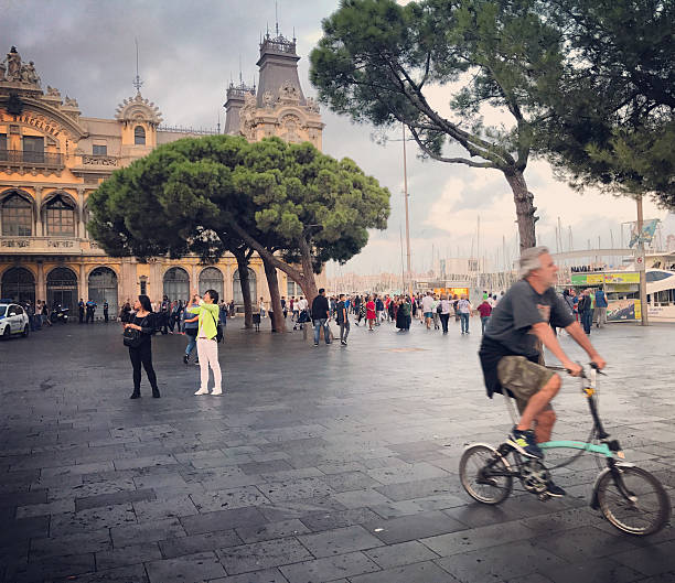 Barcelona, Spain - October 2, 2016: Tourists in Port Vell, Barcelona. Man cycling on foreground