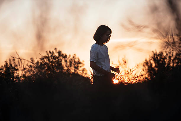 istock Young brunette standing in the sunset summer field, contemplating 615703676