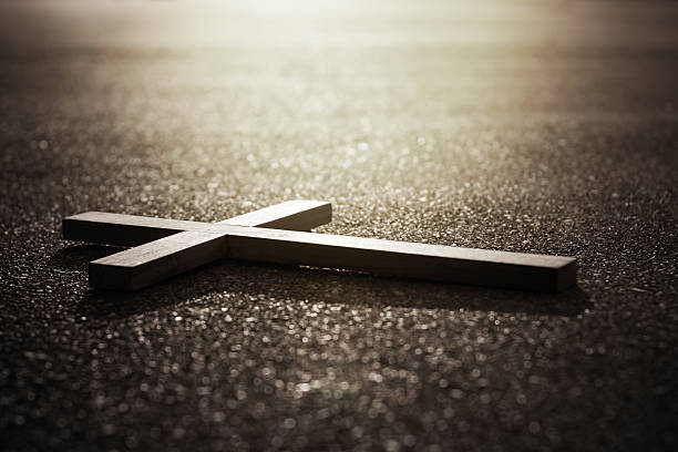 Cross and sunrise on road in dark tone