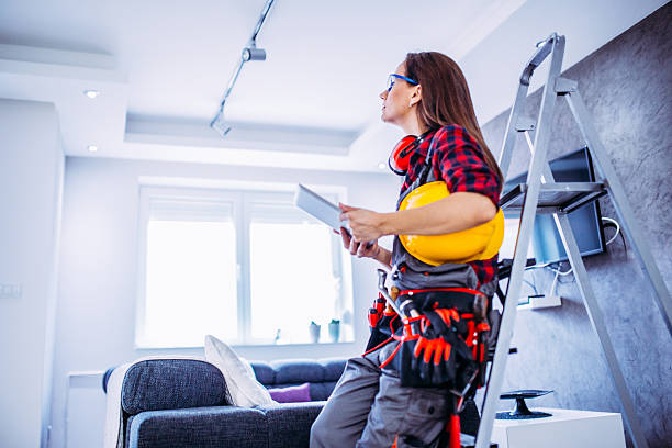 This house needs to be renovated Female construction worker with tools.Female takes care of the house.Woman handyman.There helmet on his head and a tool belt on.Tablet and search Recruiting Women Construction Workers stock pictures, royalty-free photos & images