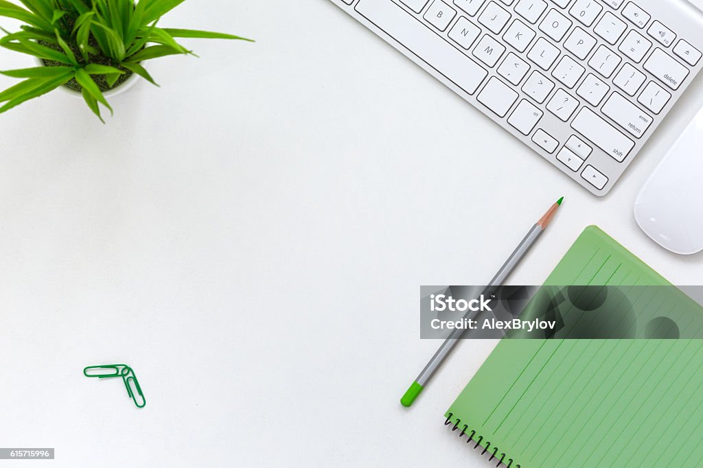 Contemporary Open Space Office white Table with Electronics and Flower Contemporary Open Space Office Theme with white Table Computer green Paper Pages Notepad Flower and Stationery top View Green Color Stock Photo