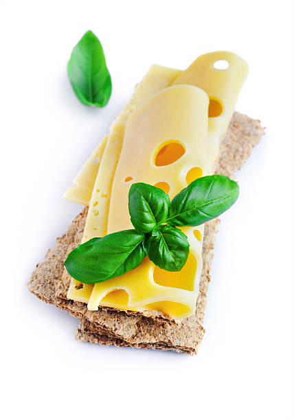 istock Maasdam cheese slices on crispbread with fresh basil 615716592