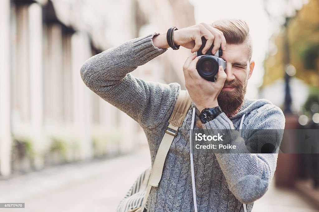 Jeune homme photographe regardant l’appareil photo - Photo de Photographe libre de droits